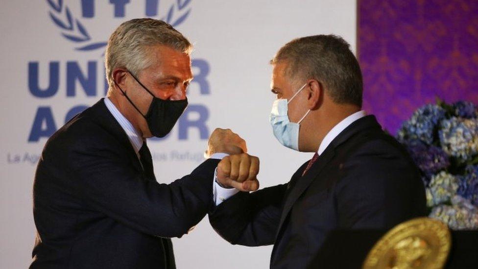 The United Nations High Commissioner for Refugees (UNHCR) Filippo Grandi bumps elbows with Colombia"s President Ivan Duque during the announcement of the granting of legal status of temporary protection to Venezuelan migrants, in Bogota, Colombia February 8, 2021.