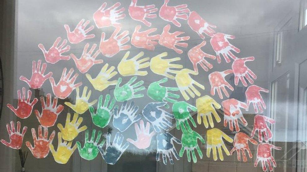 Painted rainbow hands in window