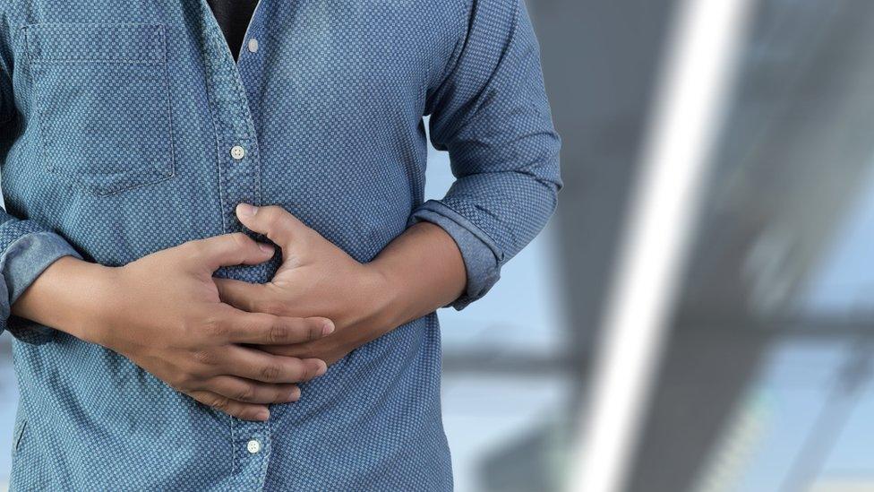 Man holding his hands over his tummy