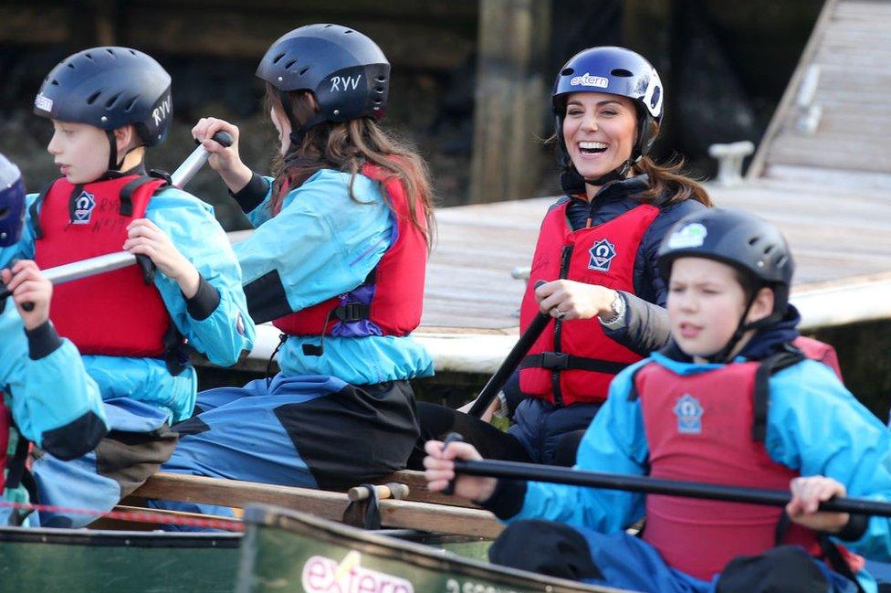 Kate laughs on board a kayak with a group of children.