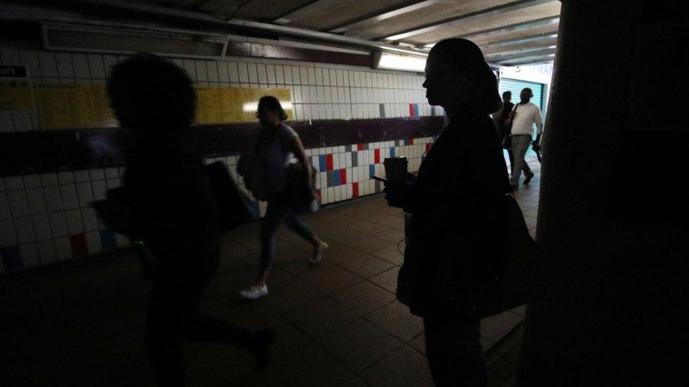 People walking in darkness in the passenger tunnel under Clapham Junction station