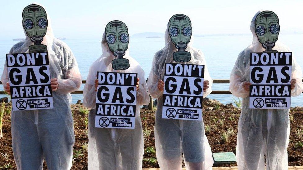 Climate activists from Extinction Rebellion hold placards outside the Africa Energy Week Conference