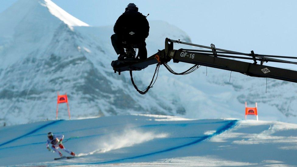 A cameraman of Swiss radio and television SRG SSR films a racer during the Lauberhorn ski races