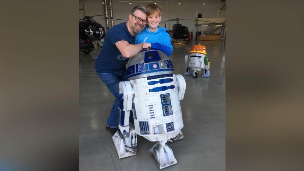 Jason Harris and his son stood with their R2-D2 replica