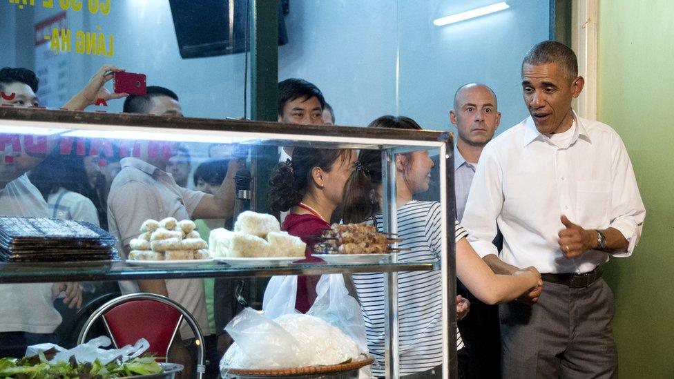 President Obama greets people at the door as he walks out from the restaurant