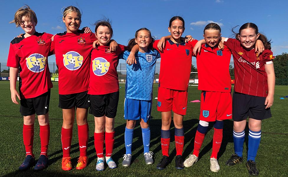 From left to right, Jemima, Maisy, Dulcie, Olive, Poppy, Lois and Cate, standing together in their football kits