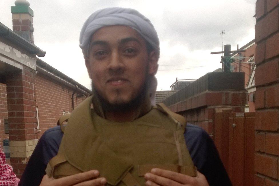 Syeedy wearing a stabproof vest in an alleyway