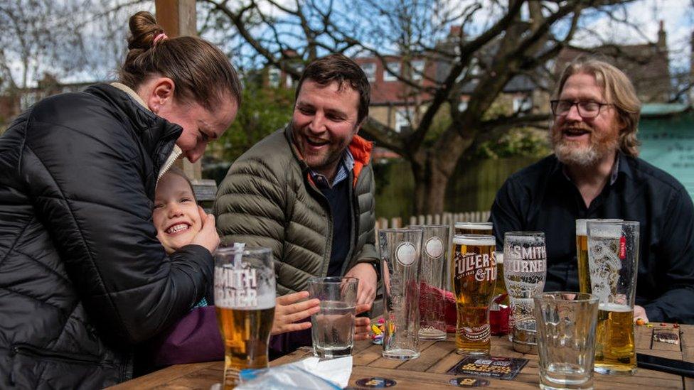 A group of people sitting at a pub garden table