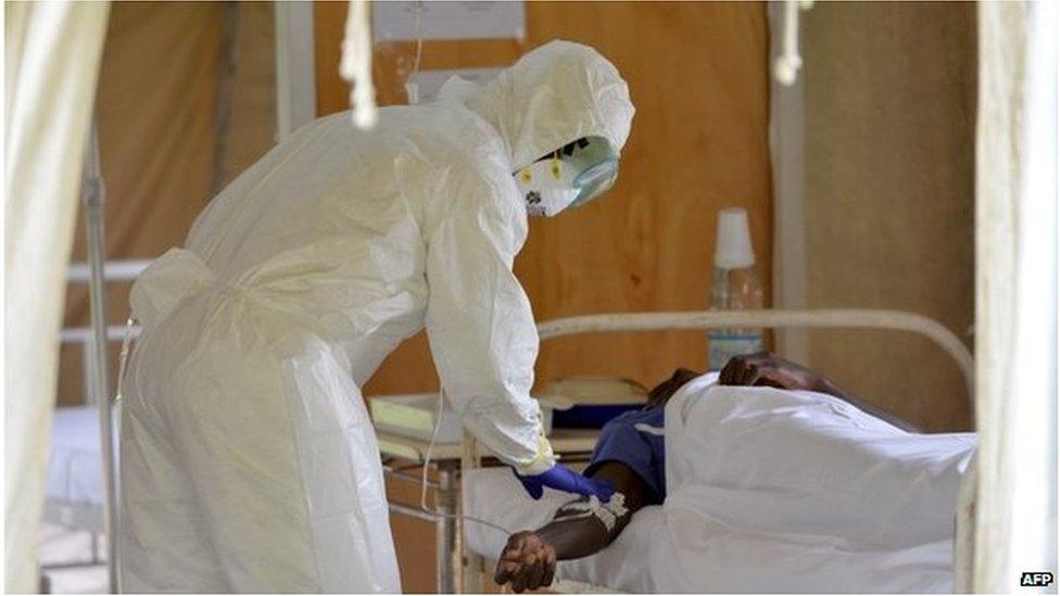 A doctor checks a man in an isolation room on August 14, 2014 at the district hospital of Biankouma.