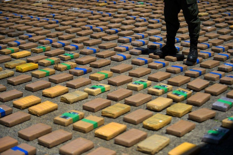 A Colombian policeman guards a one-ton shipment of cocaine seized in Buenaventura, on 10 August, 2017