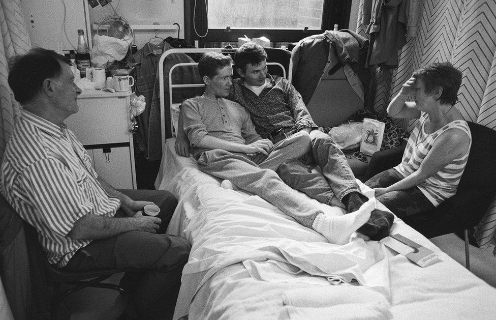 A family gather around a bedside