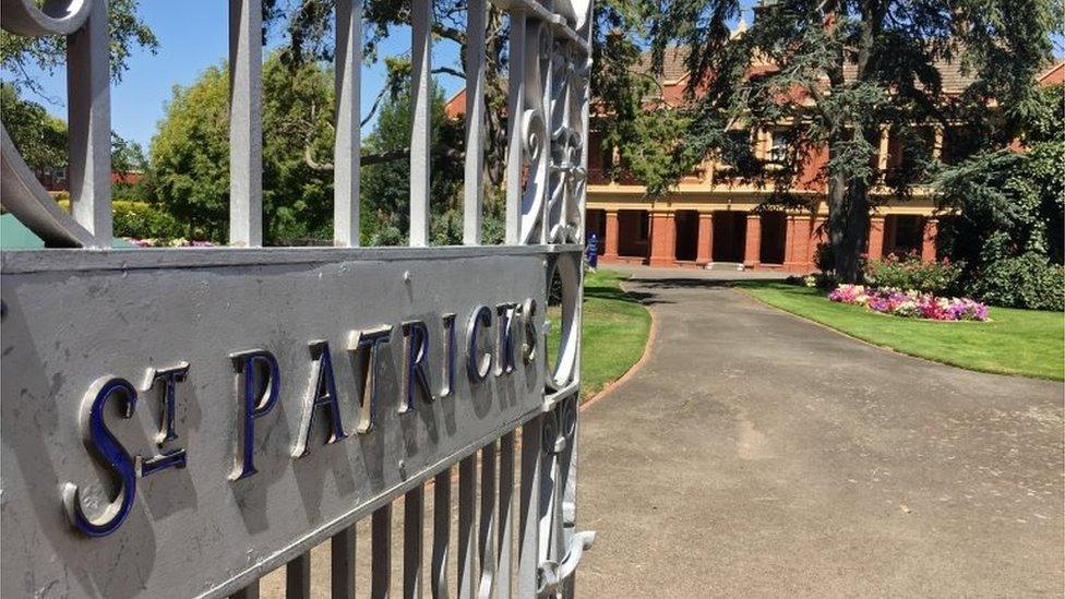 A gate reads "St Patrick's" in front of school grounds and a building