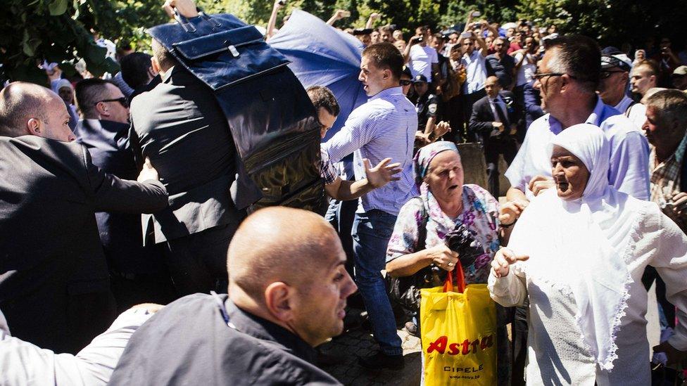 Bodyguards shield Aleksandar Vucic with umbrella at Srebrenica ceremony. 11 July 2015