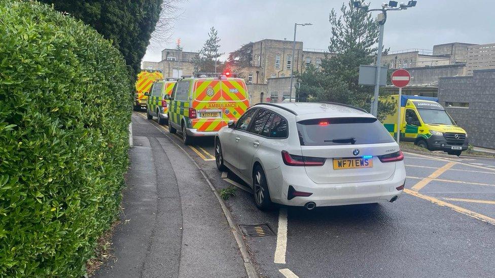 A police car behind ambulances