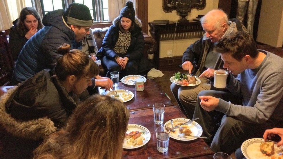 People sitting in coats eating