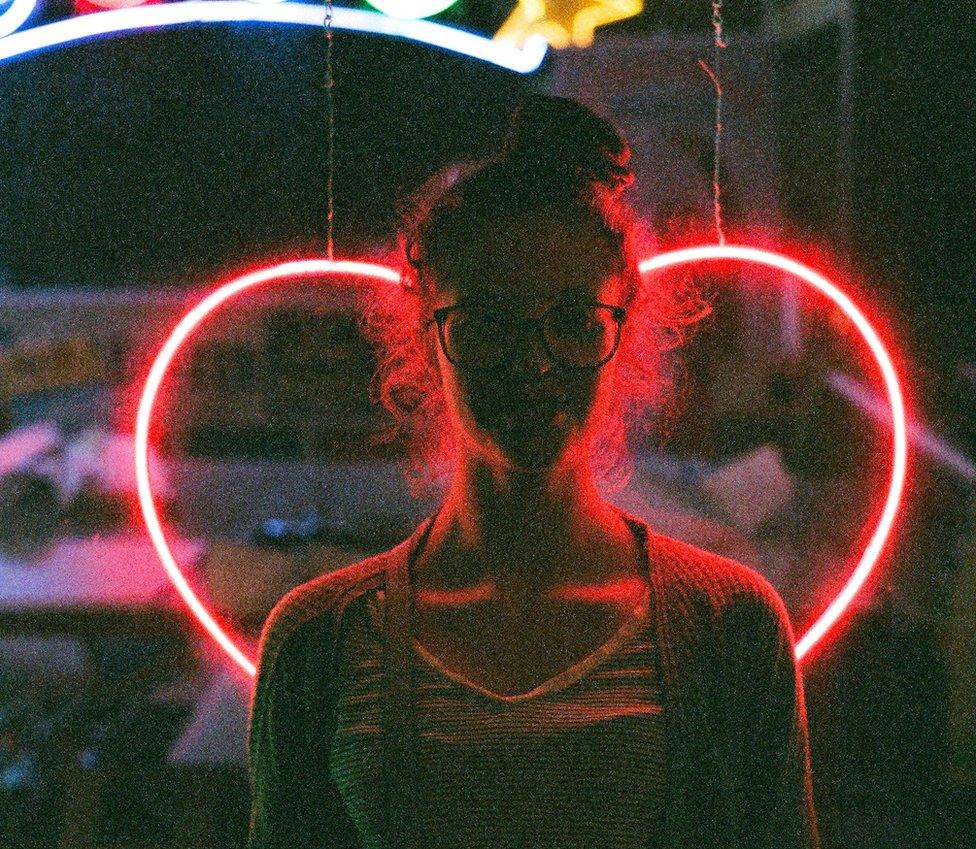 Woman in front of heart sign