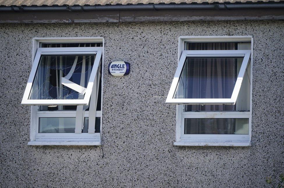 A broken window of an upstairs room in the house where the incident happened