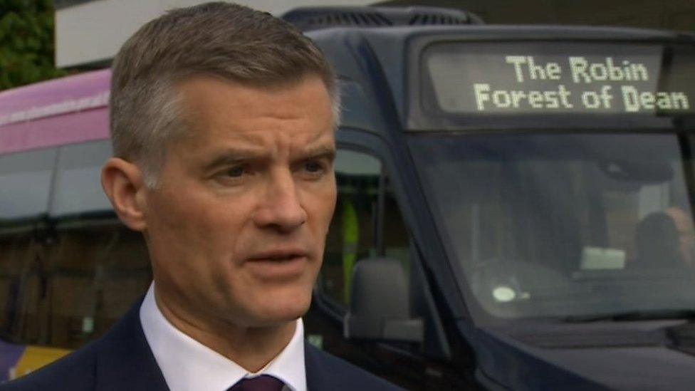 Mark Harper MP stood infront of bus