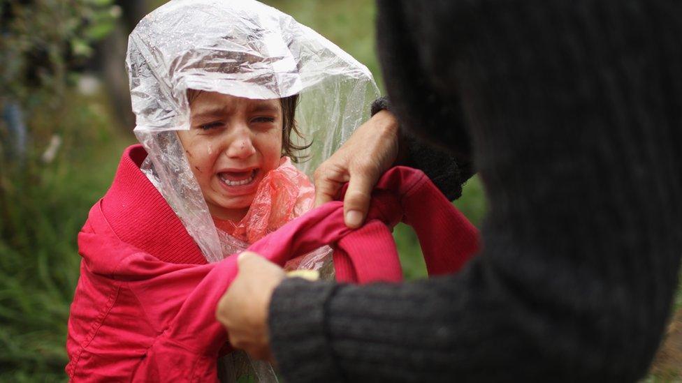 Migrant girl in the rain in Serbia