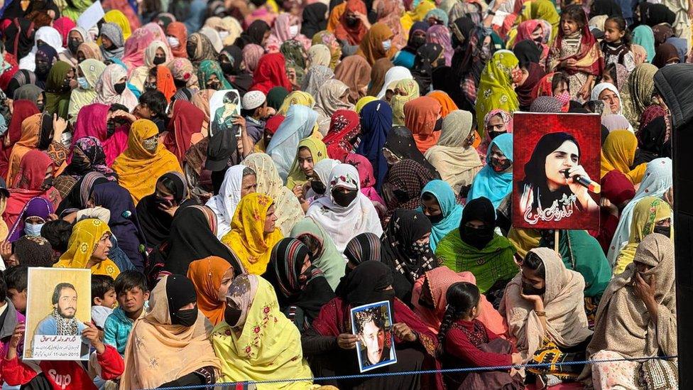 Protesters hold photos of their missing relatives, during a protest against so-called enforced disappearances