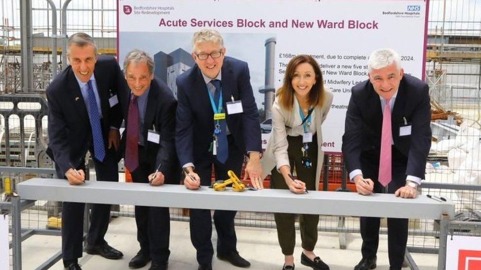 Staff signing steel to commemorate construction milestone