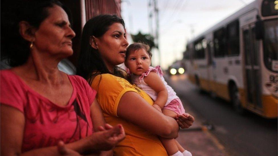 Mother Jusikelly da Silva (C) holds her 7-month-old daughter Luhandra, who was born with microcephaly, on June 1, 2016 in Recife, Brazil. Microcephaly is a birth defect linked to the Zika virus where infants are born with abnormally small heads.