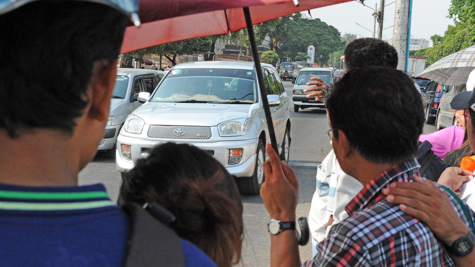 People by the side of a busy Yangon street