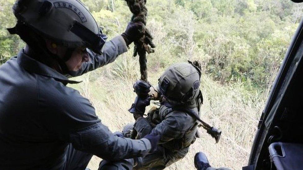 Colombian anti-narcotics policemen prepare to disembark a helicopter in a rural area of Choco on 24 February, 2015