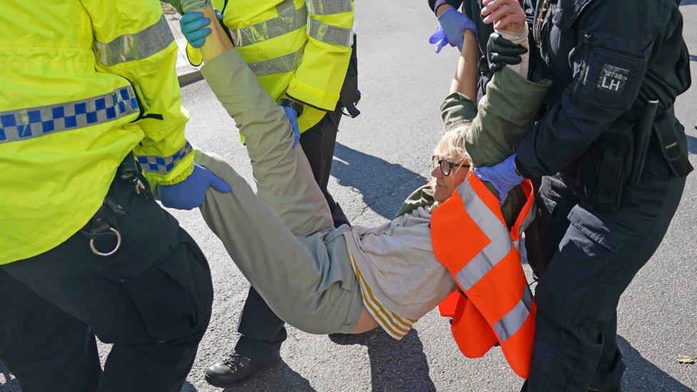 Police officers carry away a protester from the A20 in Kent