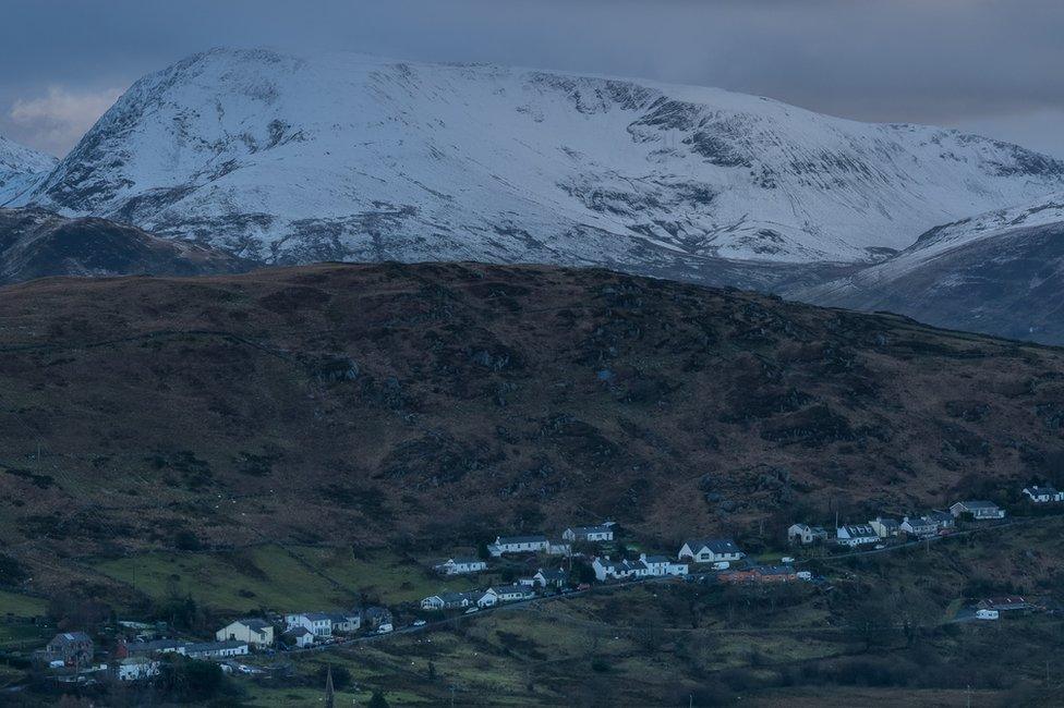 Gallt y Foel, sef yr allt sydd yn arwain i Dinorwig o Ddeiniolen, gyda'r mynyddoedd o dan eira yn y cefndir. Cafodd y llun ei dynnu o Moel Rhiwen.