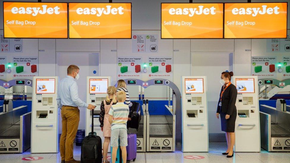 A group checking in to board an easyJet flight whilst wearing face masks