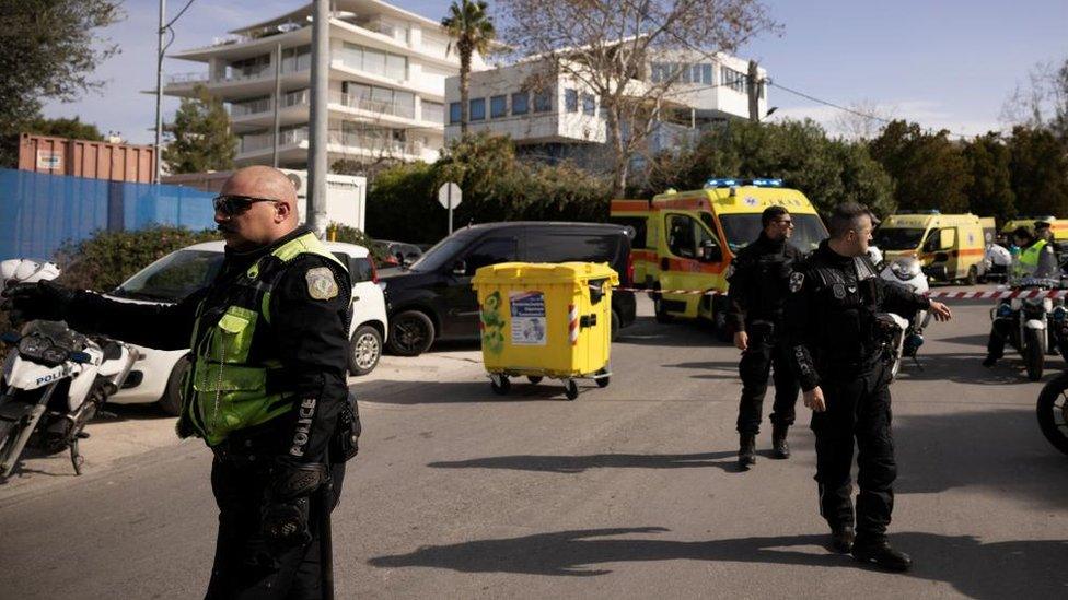 Police officers outside the office building near Athens