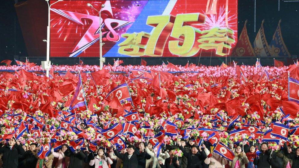 People wave flags during a military parade to mark the 75th founding anniversary of North Korea's army, in Pyongyang, North Korea February 8, 2023,