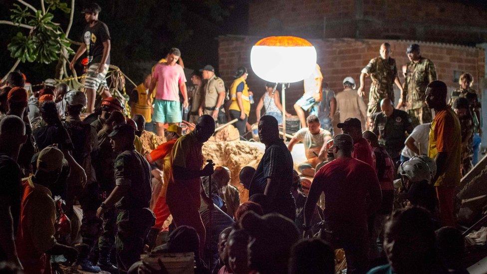 Rescuers and residents search for survivors in an area affected by a landslide