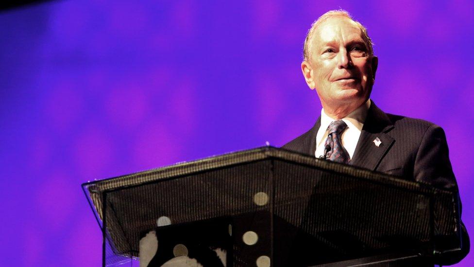 Michael Bloomberg speaking at a podium at the Christian Cultural Centre in Brooklyn