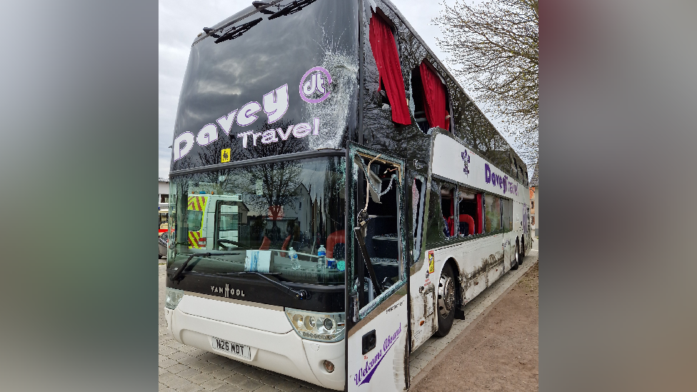 A photo showing the windows of the bus smashed