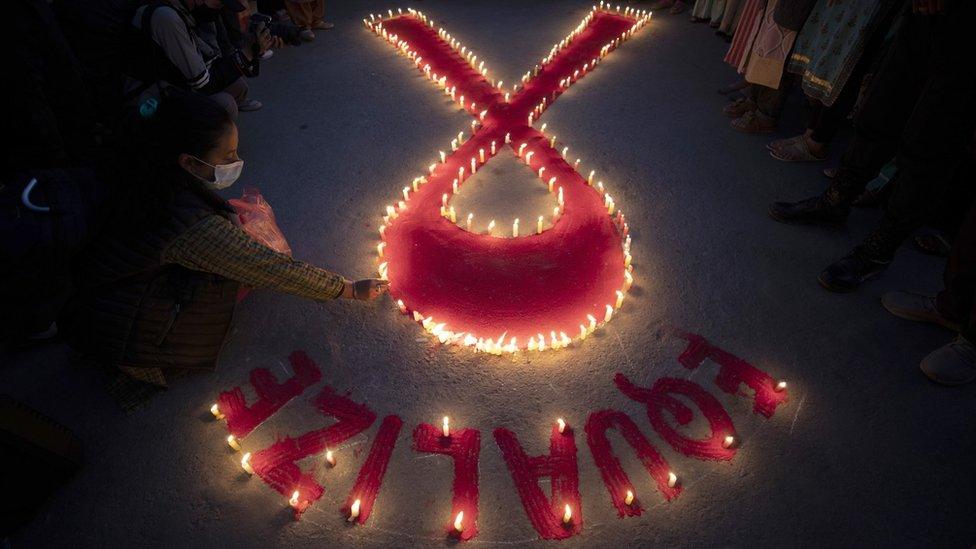 Women and children of "Maiti Nepal", a rehabilitation and orphanage home for HIV-affected people in Kathmandu, Nepal, pray for those who have lost their lives due to HIV/Aids, on the eve of World AIDS Day (30 November 2022)