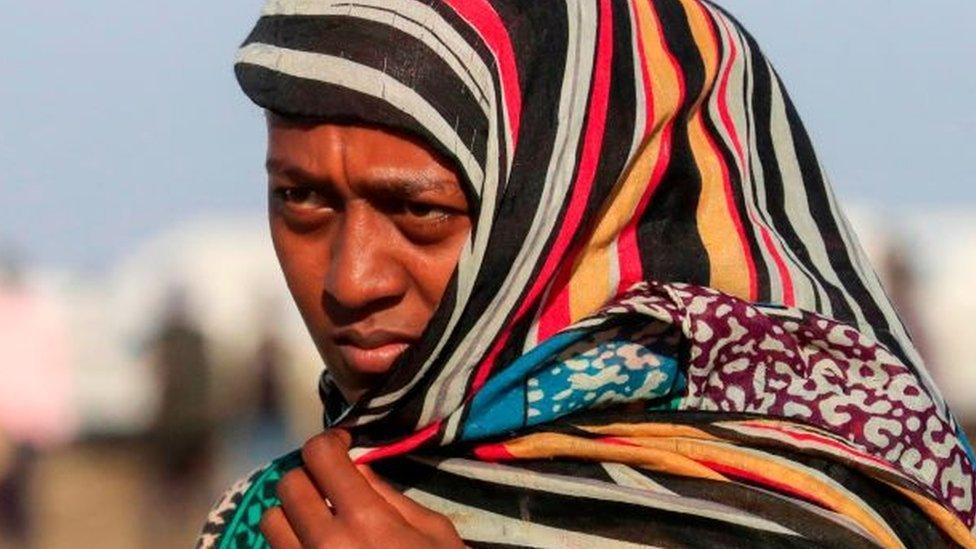 An Ethiopian refugee, who fled the Tigray conflict, walks in the Tenedba camp in Mafaza, eastern Sudan on January 8, 2021, after being transported from the reception centre