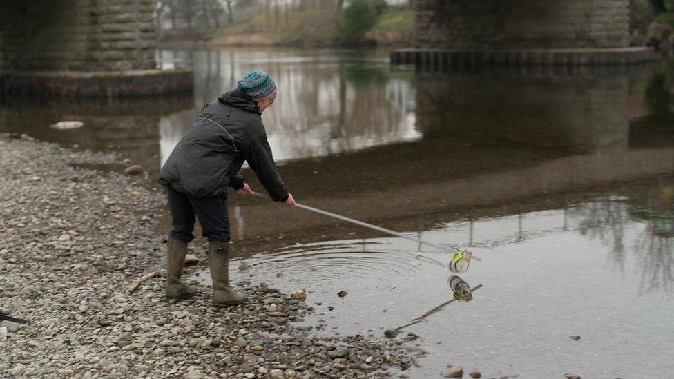 Woman testing the river