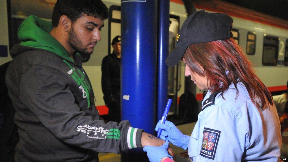 A Czech police officer marks a migrant with a number in Breclav, Czech Republic, 1 September