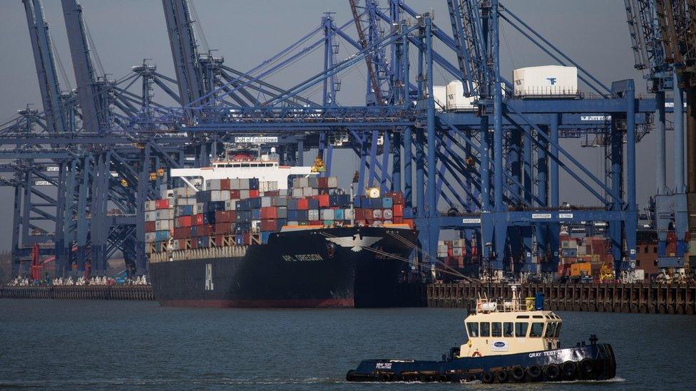 A pilot boat sails past the Felixstowe port machinery