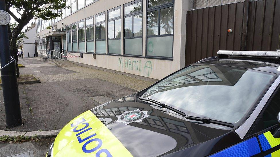 Green graffiti with M Hamill with a target symbol is sprayed outside of Newtownards court