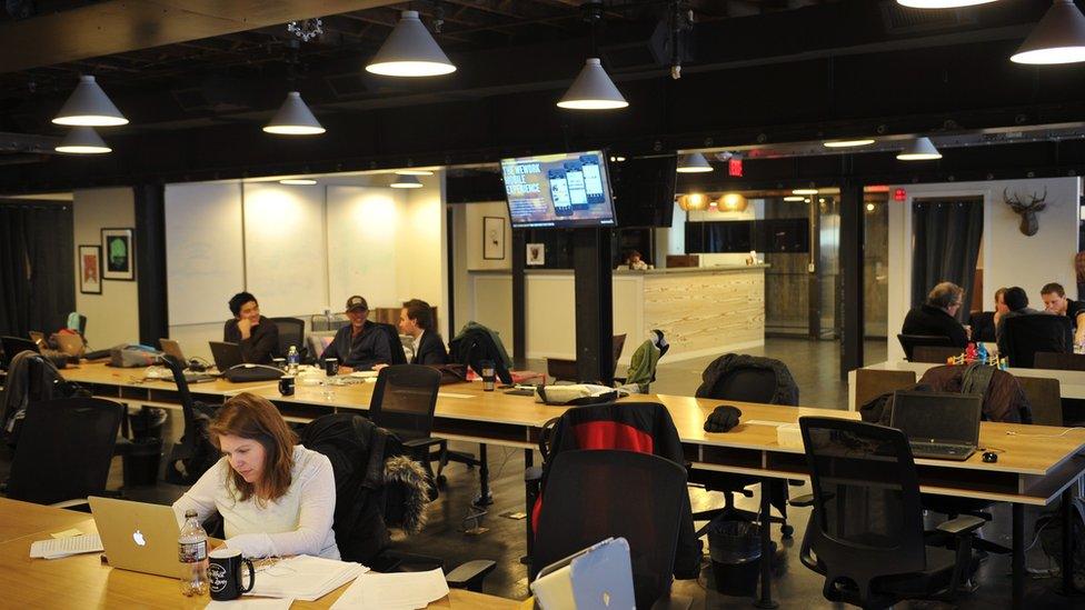 People work at tables inside of the 'WeWork' co-operative co-working space on March 13, 2013 in Washington, DC