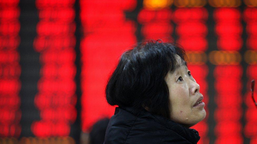 A woman watchs the eclectric monitor at A STOCK EXCHANGE in Huaibei March 9th , 2015