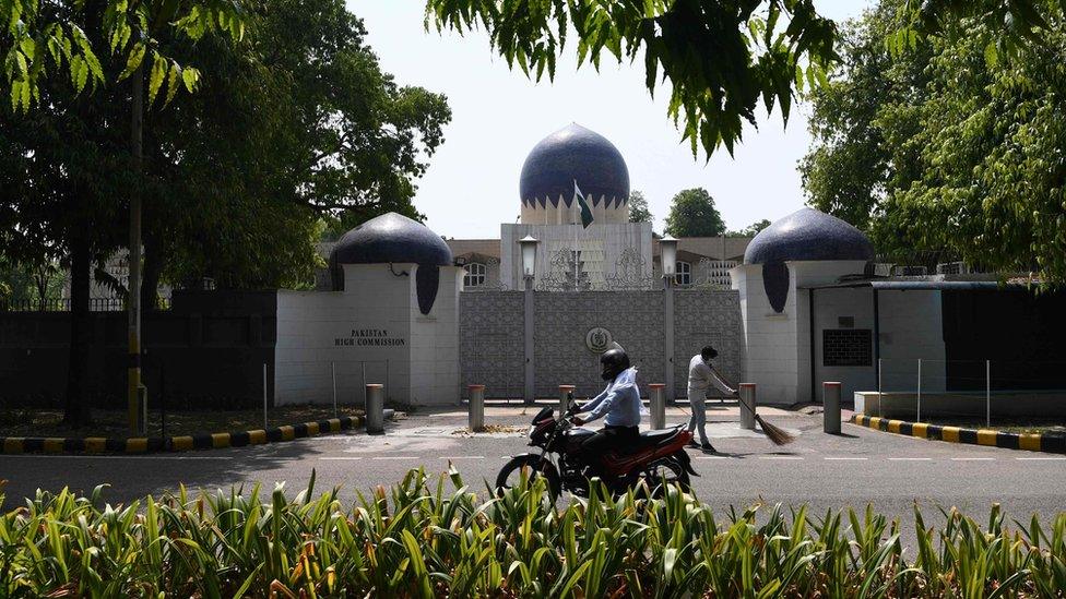 A motorist rides past the main gate of the Pakistan High Commission in Delhi, 1 June