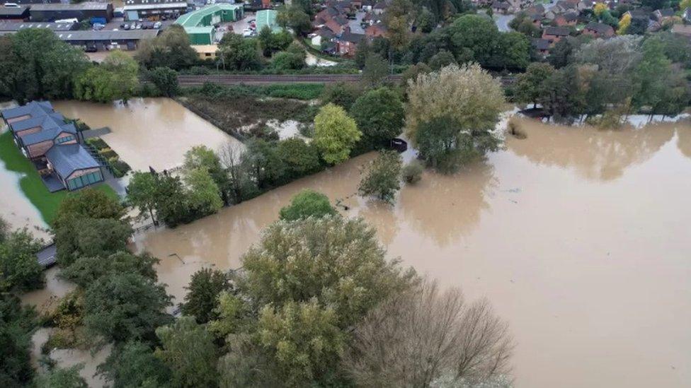 Flooded fields and water surrounding a home