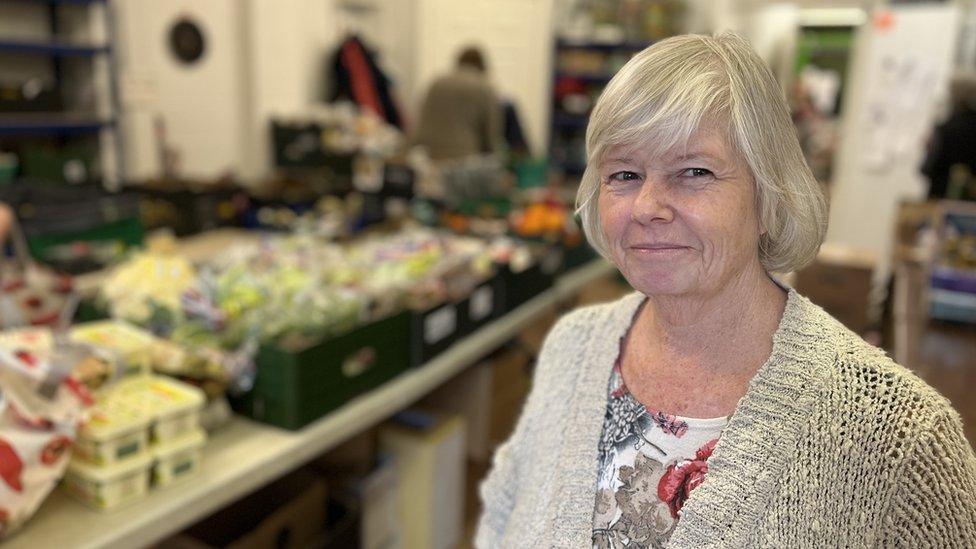 A woman standing in a foodbank room