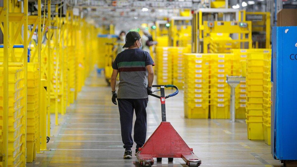 An employee pulls a cart at Amazon"s JFK8 distribution center in Staten Island, New York, U.S. November 25, 2020.