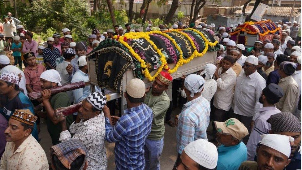 People carry the bodies of some of the victims of a suspension bridge collapse, during a funeral procession in Morbi, Gujarat state, India, 31 October 2022.