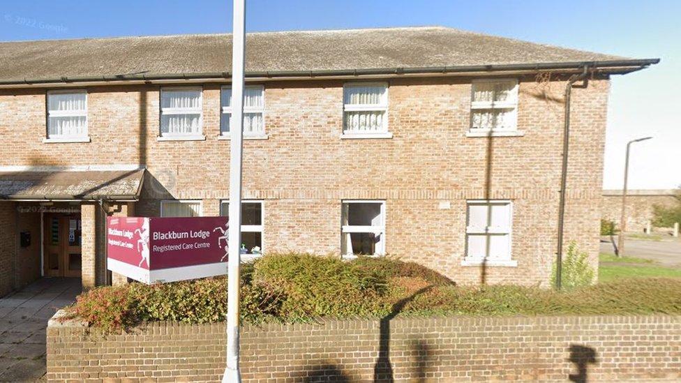 Blackburn Lodge - a two story building with a brick wall outside